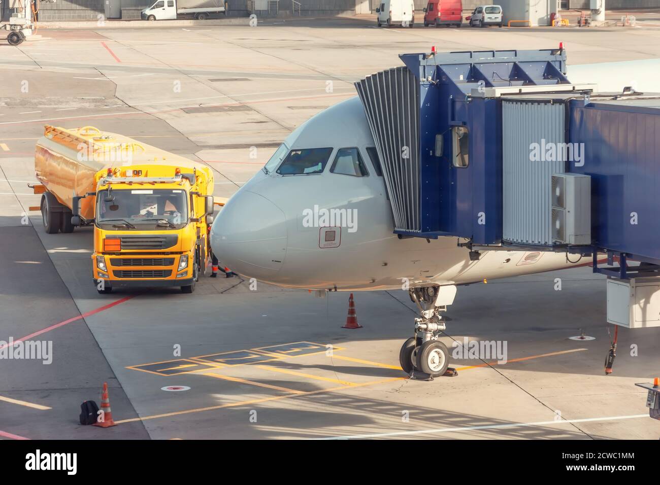 L'aeromobile nel parcheggio è collegato al ponte d'imbarco per i passeggeri provenienti dall'edificio del terminal, dal camion con serbatoio del carburante, dal rifornimento Foto Stock