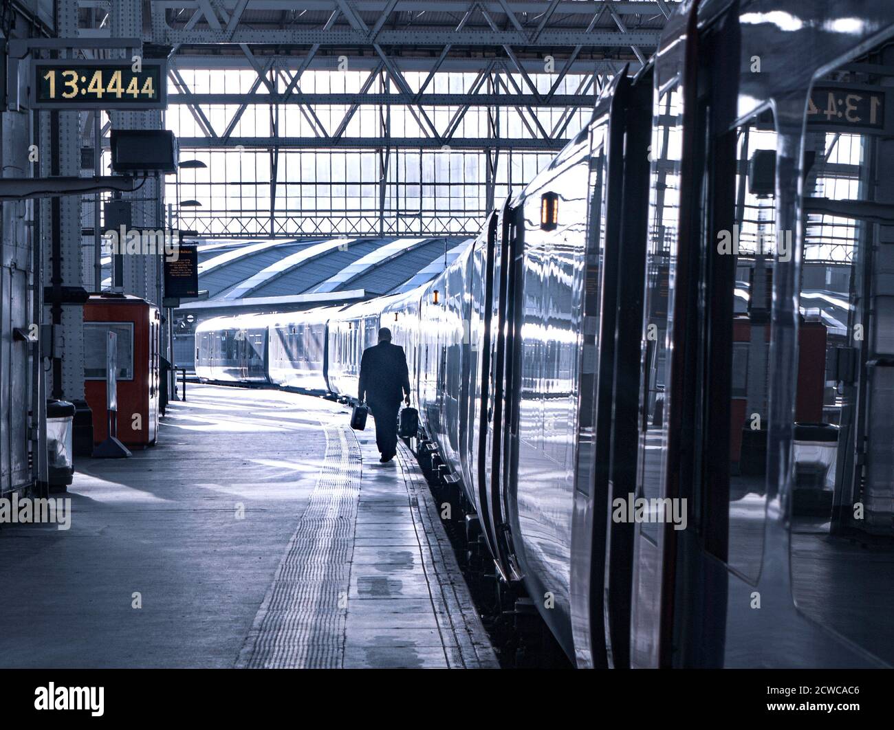 La perdita di posti di lavoro in esubero non è un concetto di disoccupazione / solo uomo che trasporta due valigette di contenuti della scrivania dell'ufficio che camminano sulla piattaforma della stazione fino al vagone ferroviario alle 17:13,44 Foto Stock