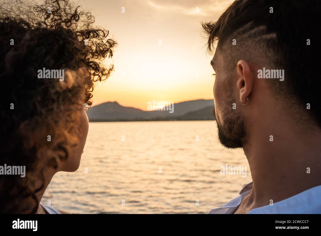 Romantico bella gara mista coppia primo piano con l'impostazione del sole in Centro della fotografia - Vista posteriore di elegante moderno giovane e il suo ispanico c Foto Stock