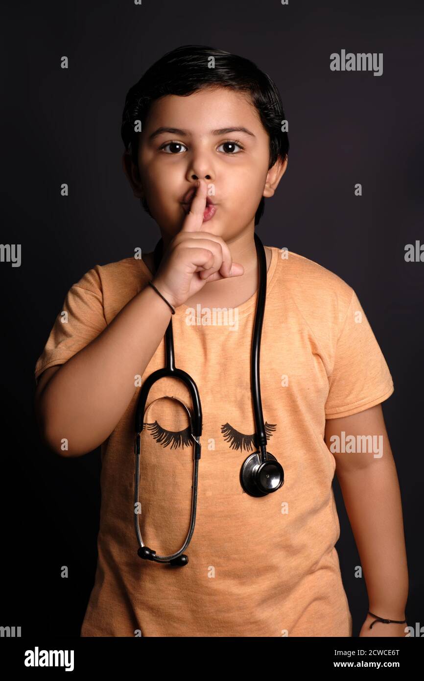 Una ragazza come un medico che chiede silenzio e silenzio, gesturando con il dito davanti alla bocca, dicendo shh o mantenendo un segreto Foto Stock