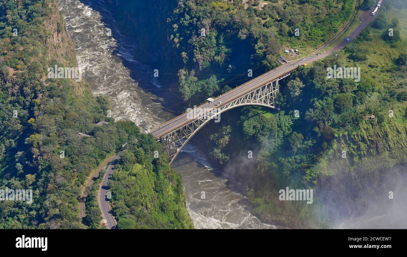 Vista aerea del famoso Victoria Falls Bridge, che segna il confine di Simbabwe e Sambia (Africa), sul fiume Sambesi con lo spruzzo delle cascate. Foto Stock