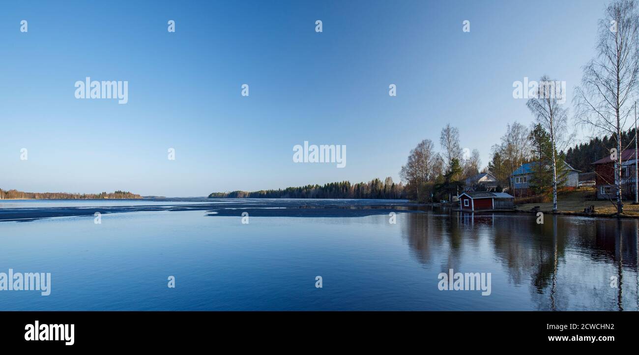 Vista su un lago di fusione a Spring, Finlandia Foto Stock