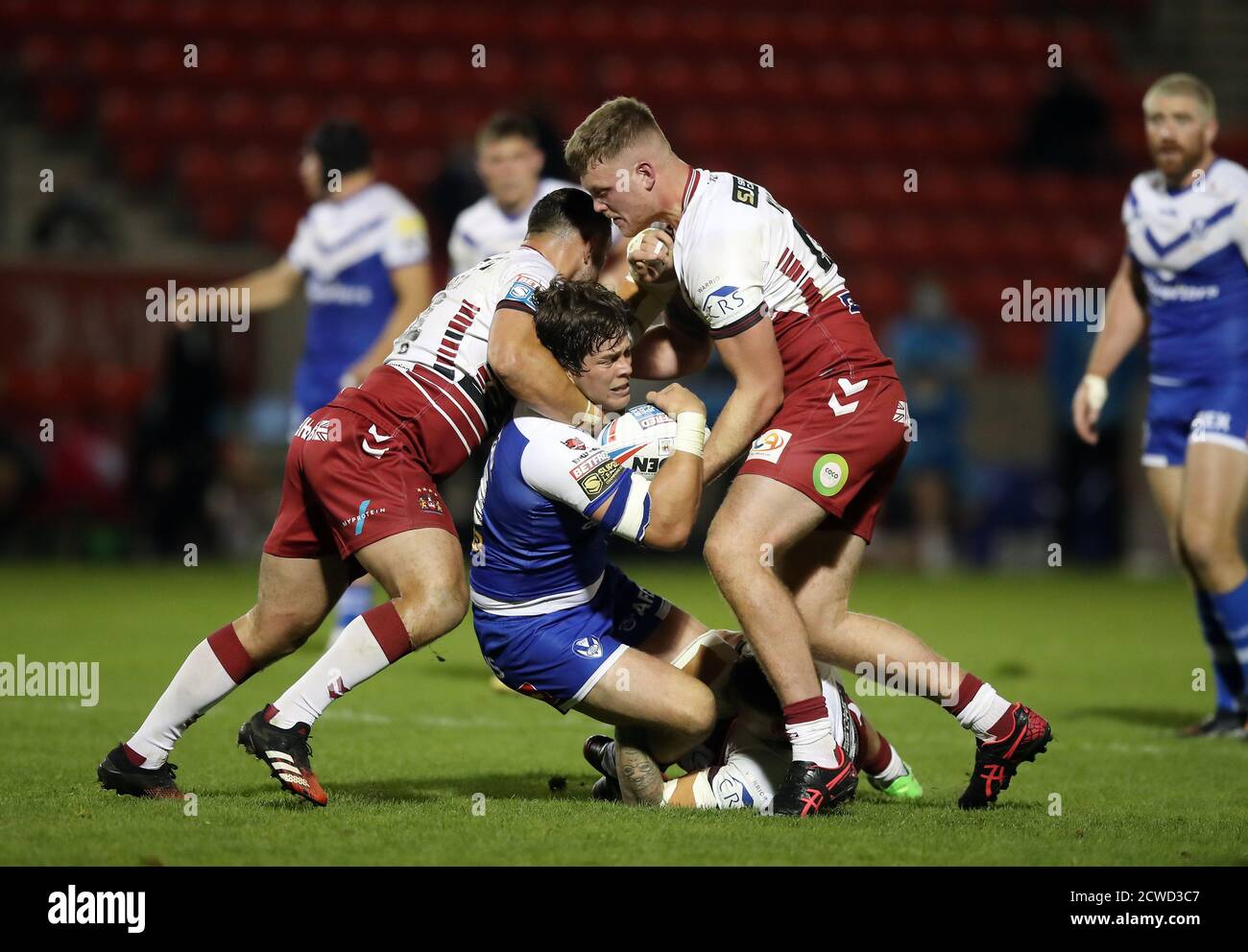 Wigan's ben Flower, ben Kilner e Amir Bourouh affrontano St Helens' Louie McCarthy-Scarsbrook durante la partita della Betfred Super League presso l'AJ Bell Stadium di Salford. Foto Stock