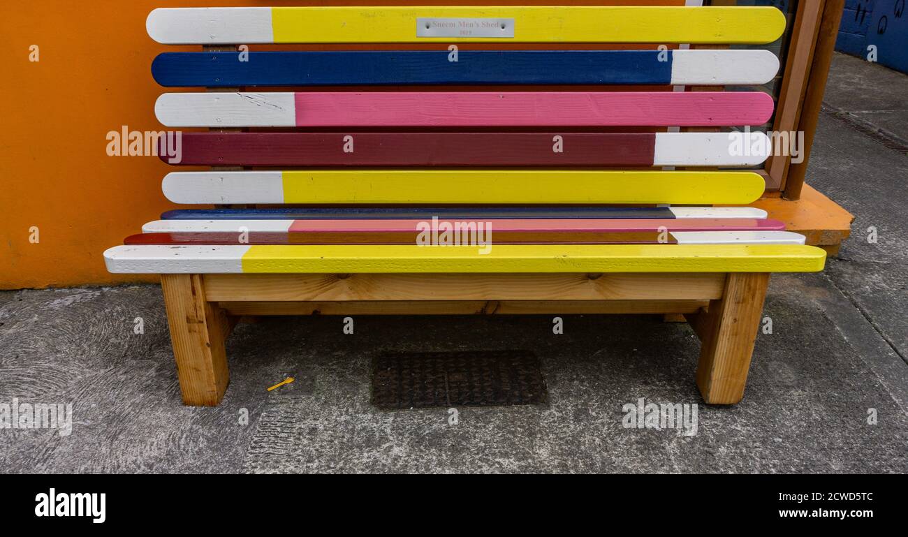 Posti a sedere pubblici colorati a Sneem, County Kerry, Irlanda, creati dal locale Mens Shed Group, un gruppo che promuove il benessere mentale/fisico per gli uomini. Foto Stock
