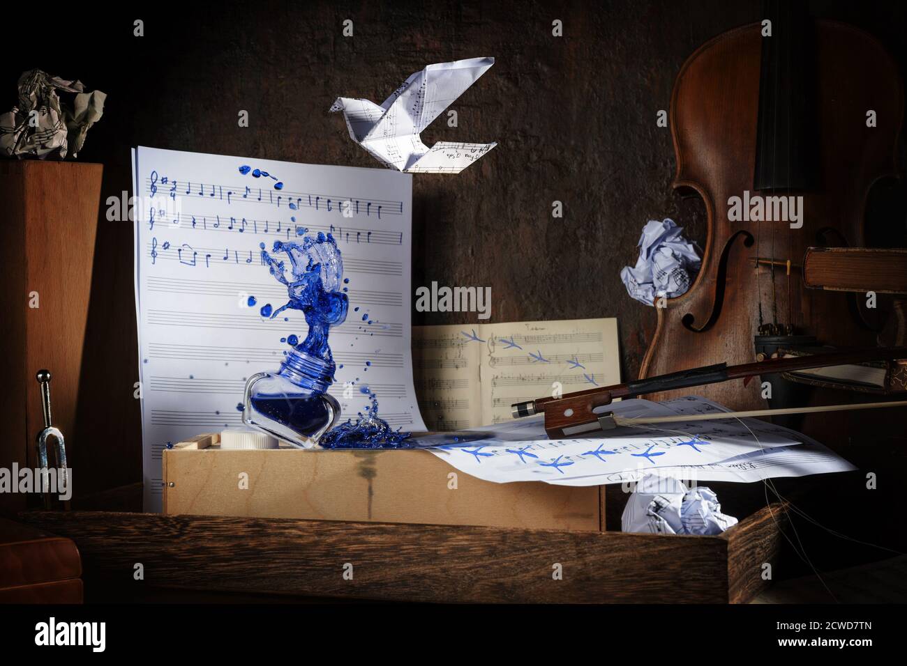 Spruzzi d'inchiostro sul luogo di lavoro rustico di un musicista con spartiti, violino, impronte e un uccello origami, scuro e moody stile, fuoco selezionato, na Foto Stock