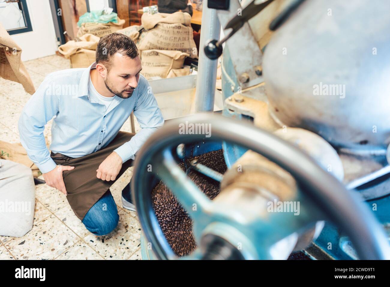 Uomo che lavora caffè tostatore Foto Stock