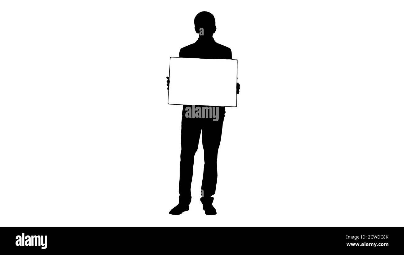 Silhouette giovane uomo d'affari che tiene un cartello vuoto guardando il camer Foto Stock