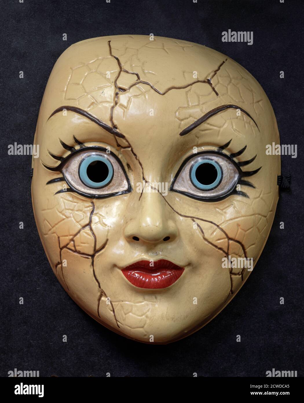 Maschera viso bambola rotta isolata contro sfondo nero Foto Stock