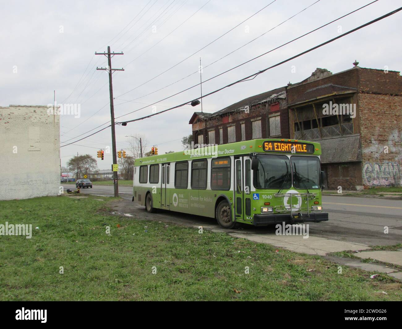 GDetroit Department of Transportation bus nel quartiere di Delray diretto A Eight Mile Road di fronte a un edificio abbandonato Foto Stock