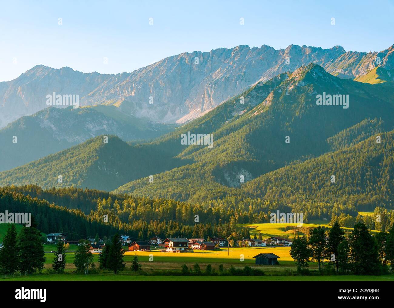 Paesaggio alpino con un piccolo villaggio austriaco appena prima del tramonto. Stato del Tirolo. Austria. Foto Stock