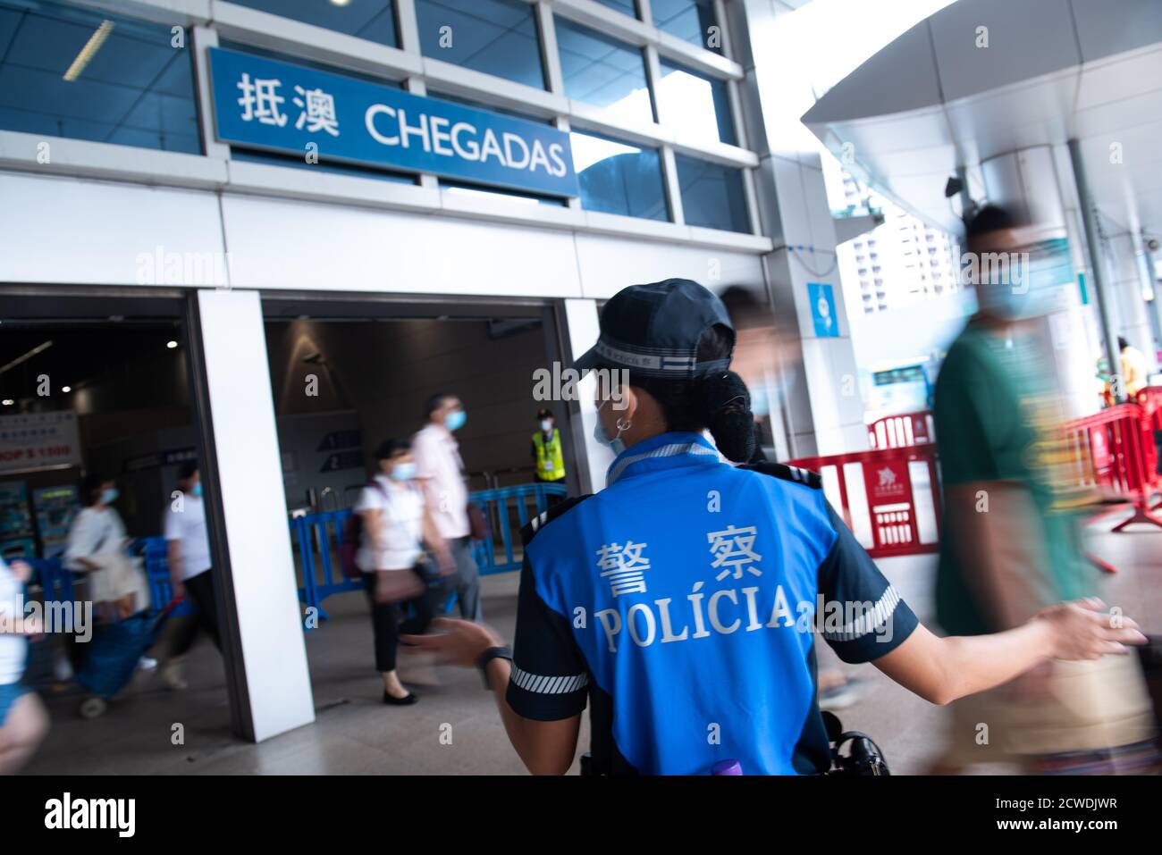 Macao, Cina. 29 Settembre 2020. Un ufficiale di polizia guida le persone quando arrivano a un porto di ingresso a Macao, Cina meridionale, 29 settembre 2020. I dipartimenti governativi della Regione amministrativa speciale cinese di Macao (SAR) sono pronti ad accogliere i turisti durante la festa nazionale del paese, con una serie di misure in atto per garantire l'ordine e la prevenzione delle pandemie, ha detto martedì le autorità locali. Credit: Cheong Kam Ka/Xinhua/Alamy Live News Foto Stock