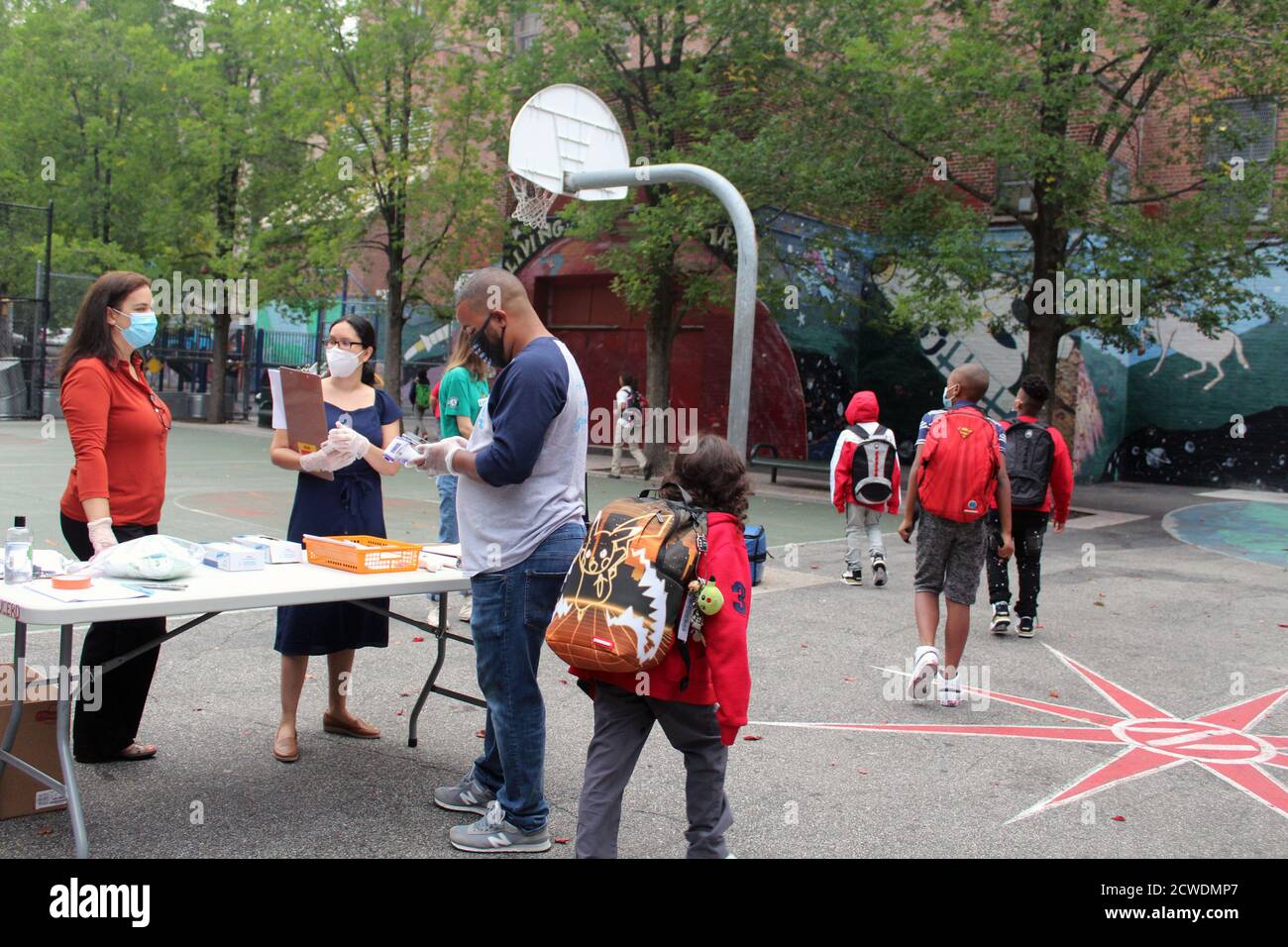 New York, New York, Stati Uniti. 28 Settembre 2020. La campana suonò alla 294 Public School nel Bronx dove i bambini tornarono a scuola come 300,000 studenti elementari a New York City dopo sei mesi di chiusura. Diversi bambini attraversano il cortile della scuola dopo aver superato il checkpoint all'ingresso della struttura. Tuttavia, il ritorno a scuola potrebbe essere rimesso in discussione, poiché il Covid-19 riapparve in diversi distretti. Inoltre, molti genitori e insegnanti contestano il programma di ritorno a scuola istituito dal sindaco Bill de Blasio, ritenendo che le misure sanitarie non siano sufficientemente sicure. (Immagine di credito: © Marie L Foto Stock