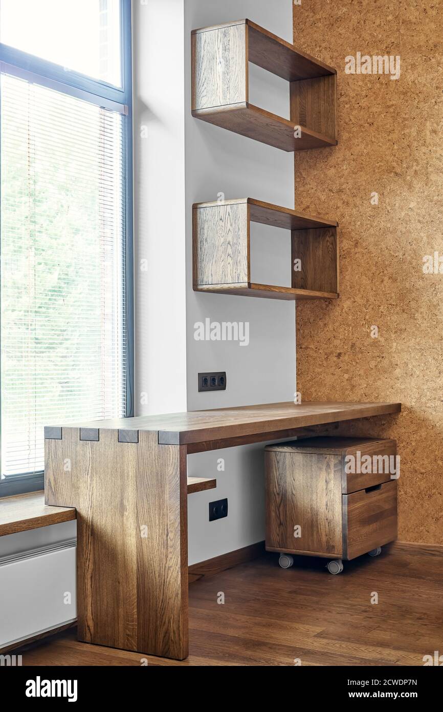 Arredamento moderno. Box joint scrivania console in legno massiccio con ripiani sullo sfondo della finestra Foto Stock