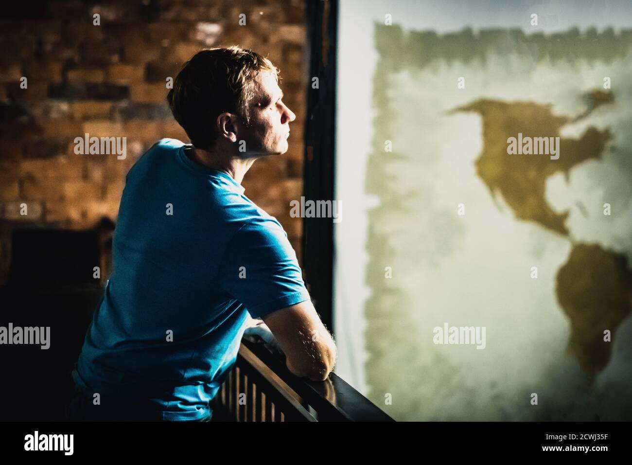 Uomo che guarda lontano grande muro sfondo mappa del mondo. L'isolamento globale ha chiuso i paesi a causa della pandemia di Coronavirus COVID 19. Diffusione del virus Concept Foto Stock