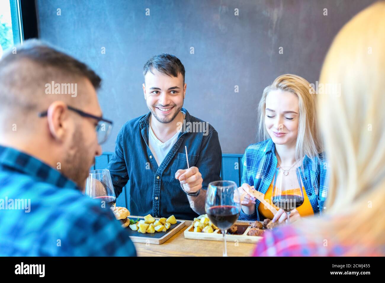 Le coppie felici si divertono mentre si gustano il pranzo al fast food ristorante Foto Stock