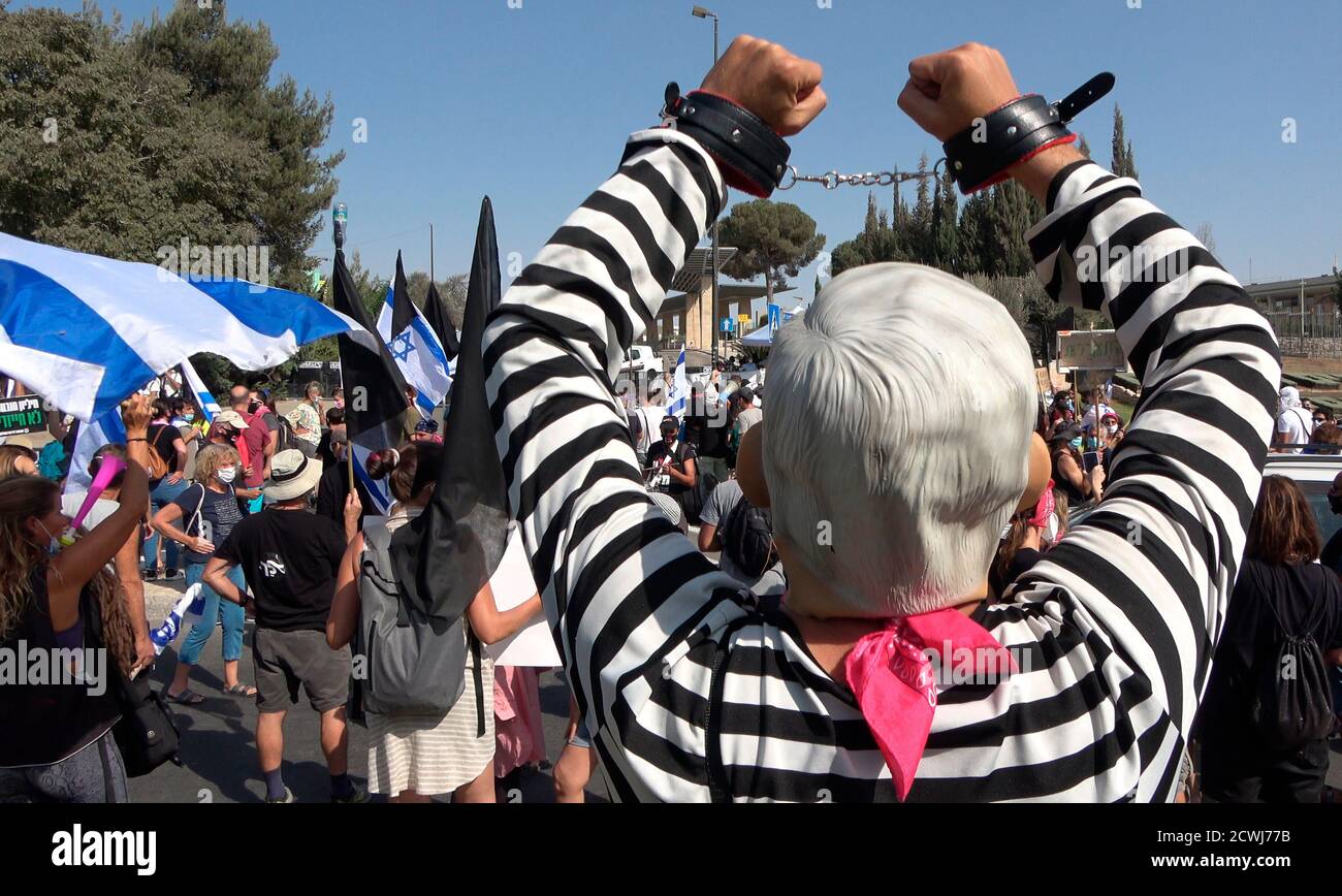 GERUSALEMME, ISRAELE - 29 SETTEMBRE: Un protestore che indossa un'uniforme carceraria solleva le mani in maniche davanti al parlamento israeliano durante una manifestazione sulla legislazione che limita le proteste in un blocco a livello nazionale volto a contenere la pandemia del coronavirus il 29 settembre 2020 a Gerusalemme, Israele. Il parlamento israeliano ha approvato modifiche alla legge del Coronavirus che limiterebbero le proteste contro il primo ministro Benjamin Netanyahu chiedendo le sue dimissioni per la sua accusa di corruzione e la gestione della pandemia del coronavirus. Foto Stock