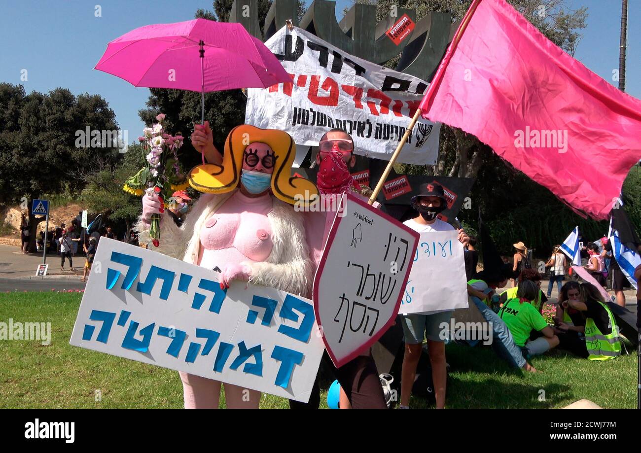 GERUSALEMME, ISRAELE - 29 SETTEMBRE: Un manifestante vestito da un busty costume cartoon tiene un cartello che recita "la democrazia era qui" di fronte al parlamento israeliano durante una manifestazione sulla legislazione che limita le proteste in un blocco a livello nazionale volto a contenere la pandemia del coronavirus il 29 settembre 2020 a Gerusalemme, Israele. Il parlamento israeliano ha approvato modifiche alla legge del Coronavirus che limiterebbero le proteste contro il primo ministro Benjamin Netanyahu chiedendo le sue dimissioni per la sua accusa di corruzione e la gestione della pandemia del coronavirus. Foto Stock