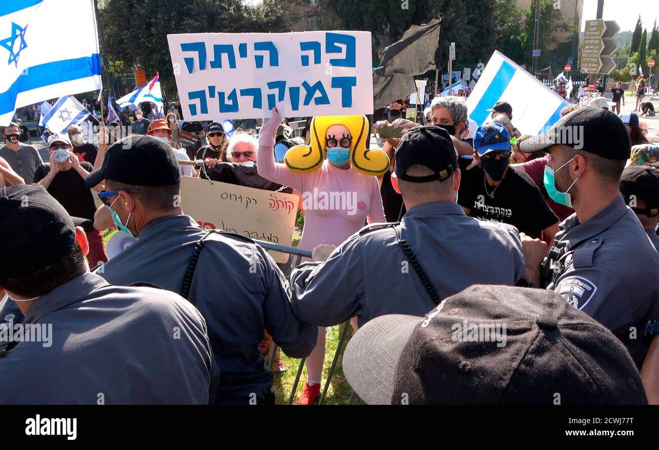 GERUSALEMME, ISRAELE - 29 SETTEMBRE: Un manifestante vestito da un busty costume cartoon tiene un cartello che recita "la democrazia era qui" di fronte al parlamento israeliano durante una manifestazione sulla legislazione che limita le proteste in un blocco a livello nazionale volto a contenere la pandemia del coronavirus il 29 settembre 2020 a Gerusalemme, Israele. Il parlamento israeliano ha approvato modifiche alla legge del Coronavirus che limiterebbero le proteste contro il primo ministro Benjamin Netanyahu chiedendo le sue dimissioni per la sua accusa di corruzione e la gestione della pandemia del coronavirus. Foto Stock