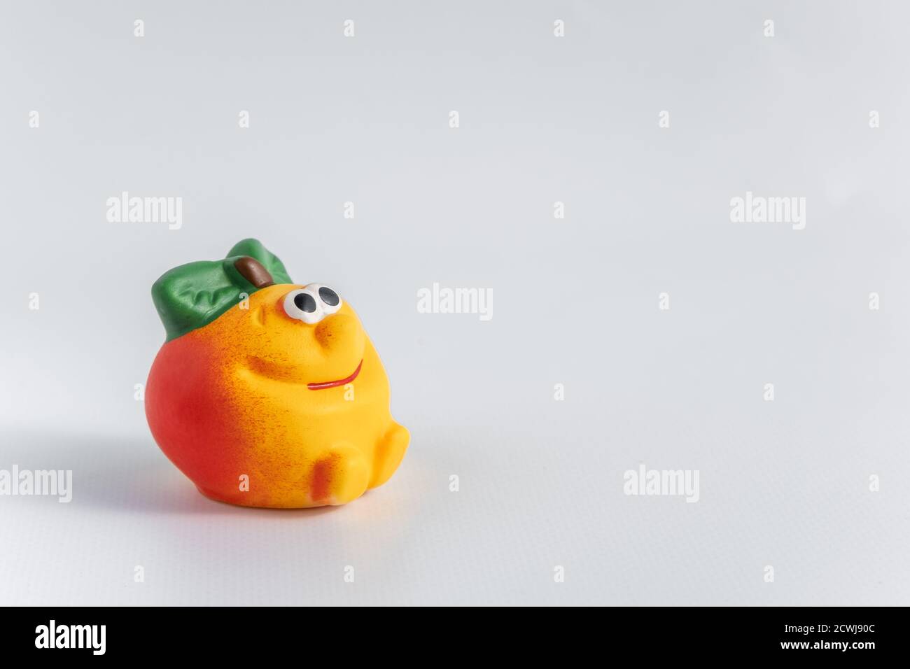 Mela giocattolo di gomma per bambini, su sfondo bianco. Un giocattolo carino per vari giochi per bambini. Sviluppo e giochi con bambini. Spazio di copia. Primo piano Foto Stock