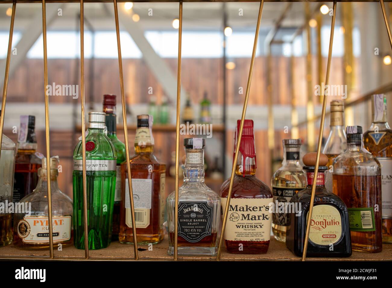 fila di bottiglie di alcool su scaffale di legno in una cucina raffinata ristorante Foto Stock