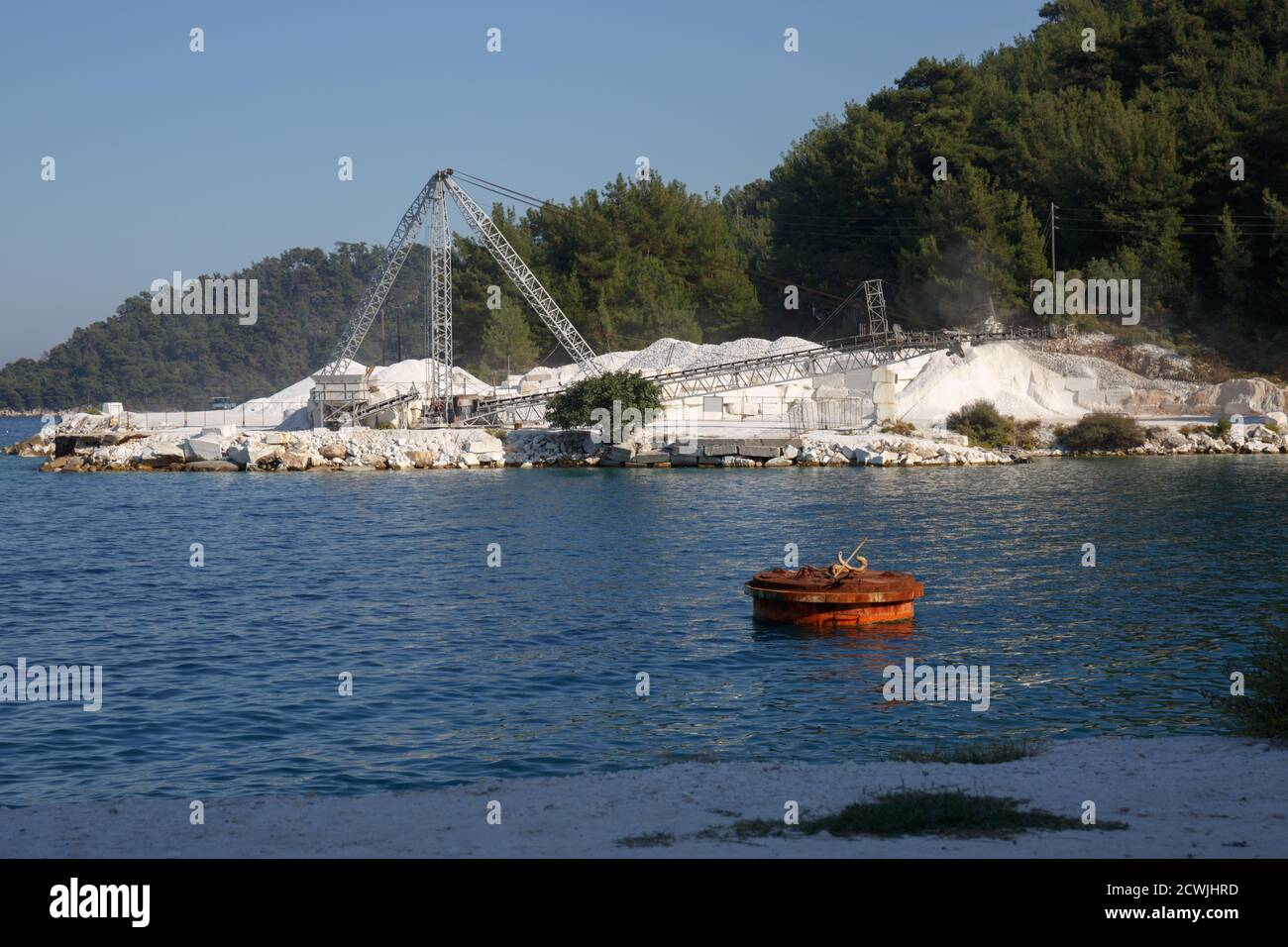 Spiaggia di Porto Vathy sull'isola di Thassos. Miniera di marmo bianco con nastro trasportatore sull'isola. Thasos, Grecia, ottobre 2019 Foto Stock