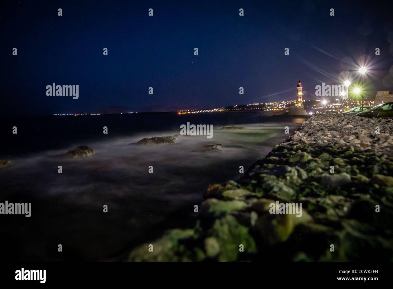 Visione notturna: Vista sul porto veneziano con un vecchio faro Foto Stock
