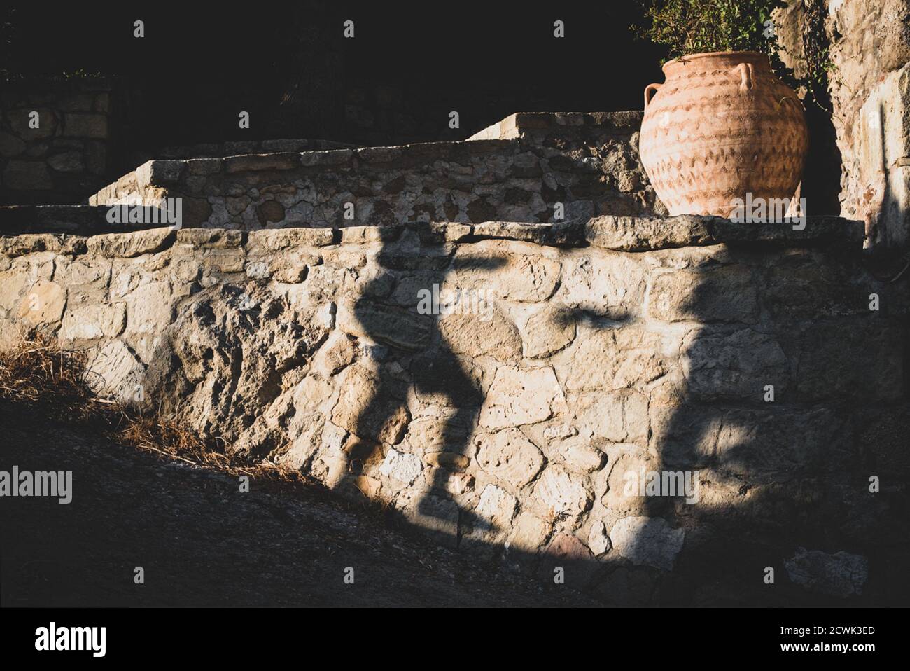 Ombra passando per le strade del vecchio villaggio cretese. Foto Stock