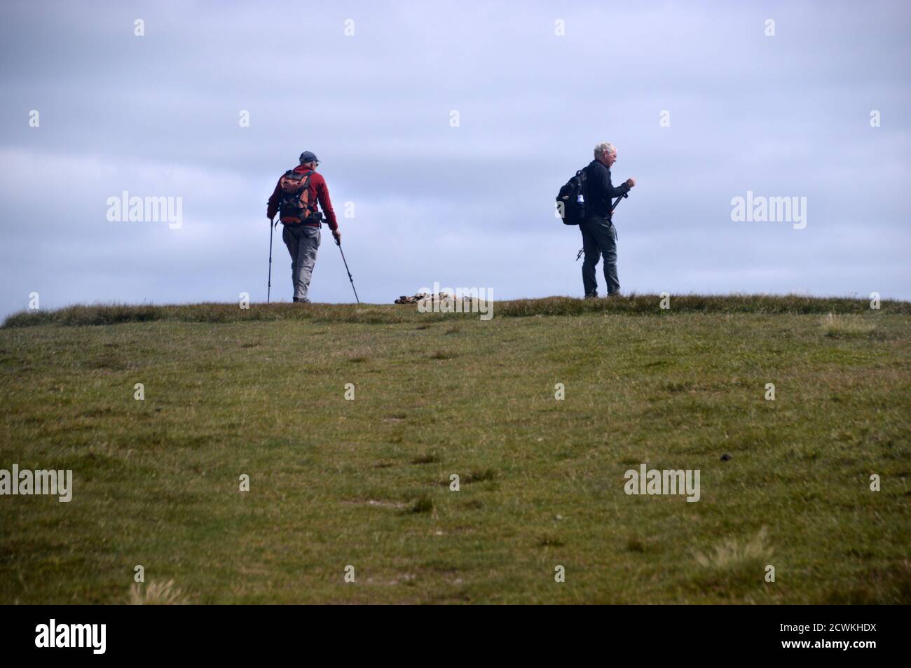Two Men Walking & Standing by the pile of Stones sulla cima Cairn del Wainwright 'Wandope' nel Lake District National Park, Cumbria. REGNO UNITO. Foto Stock