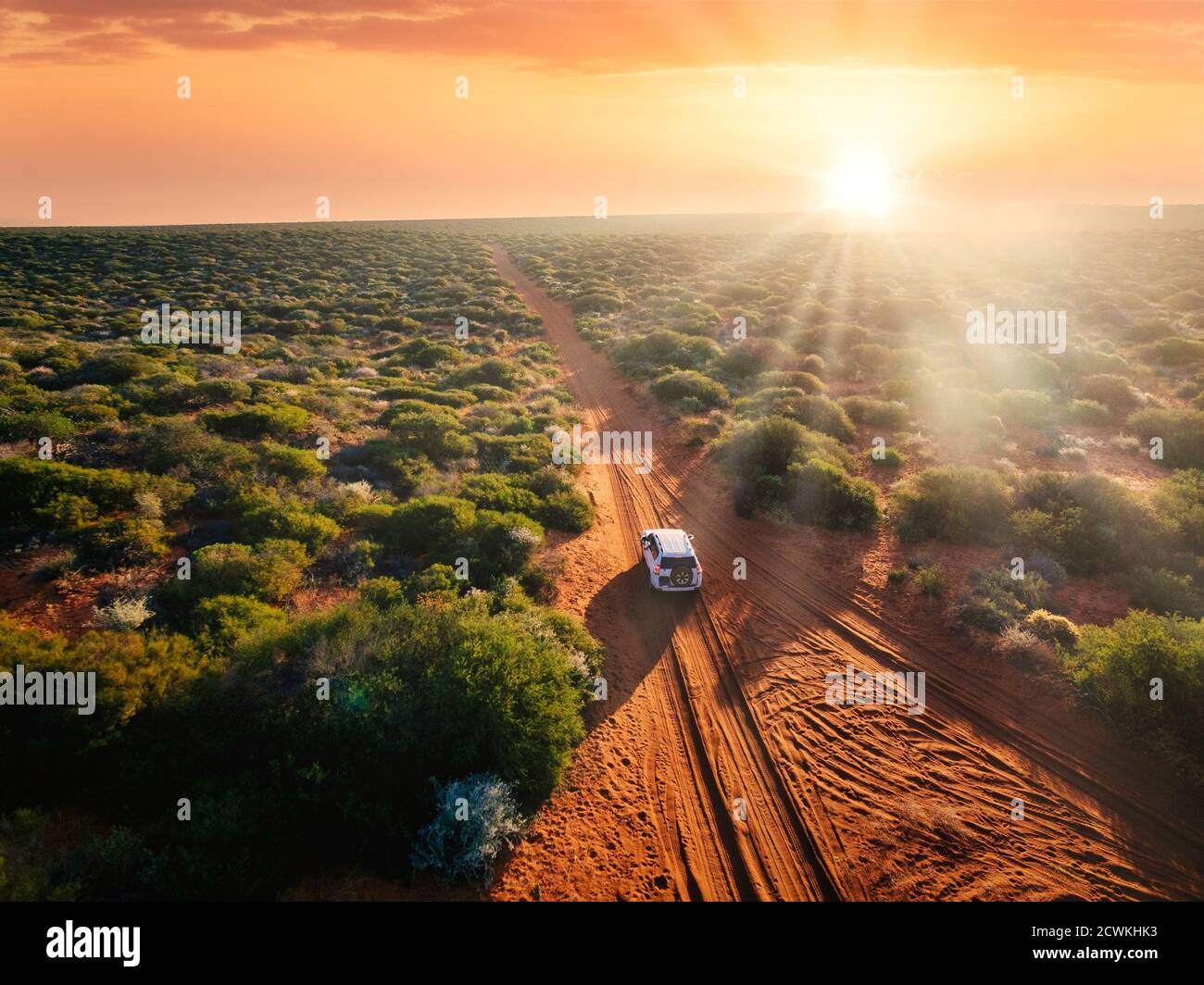 Australia, strada sterrata di sabbia rossa e 4x4 al tramonto, Outback libertà Foto Stock