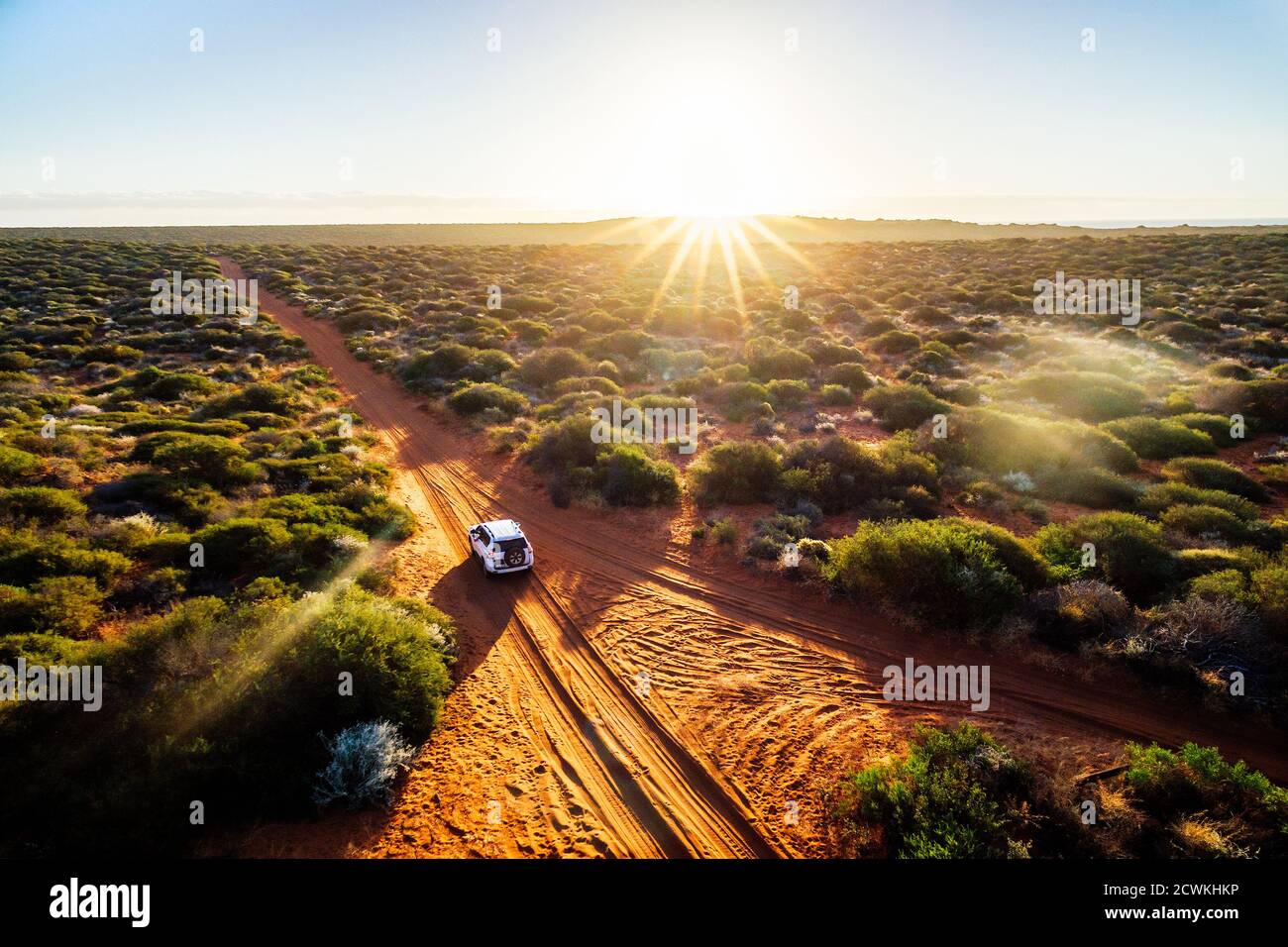 Australia, strada sterrata di sabbia rossa e 4x4 al tramonto, Outback libertà Foto Stock