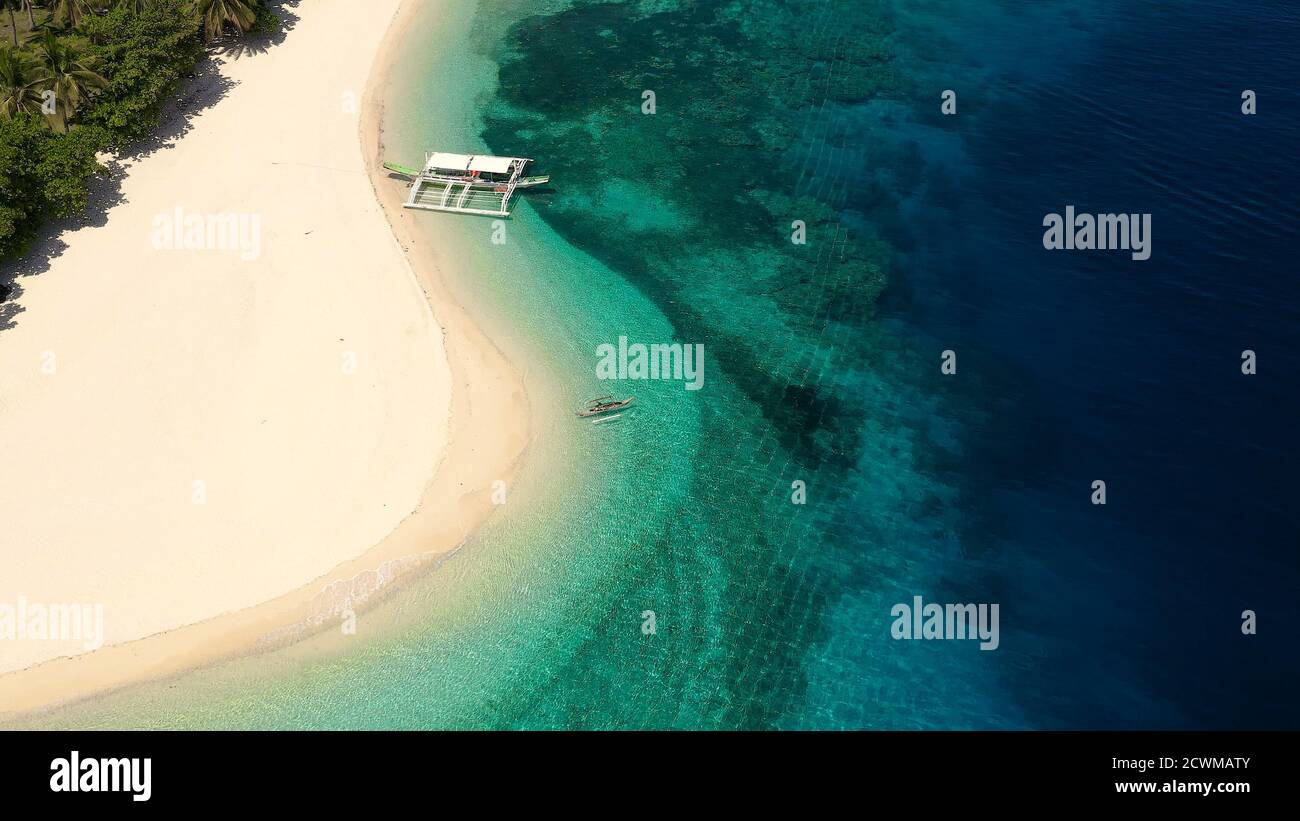 Seascape con una bella isola tropicale, vista aerea. Una bellissima spiaggia di sabbia bianca. Mahaba Isola, Filippine. Mare blu con le lagune turchesi. Estate viaggi e concetto di vacanza. Foto Stock