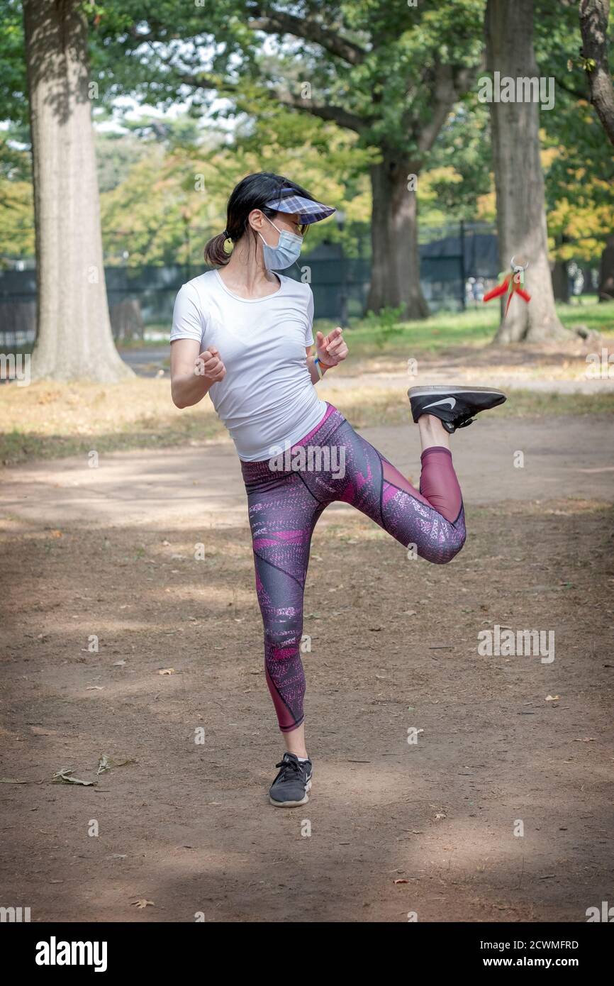 Una donna cinese americana agile gioca a Jianzi in un parco a Queens, New York City. Foto Stock