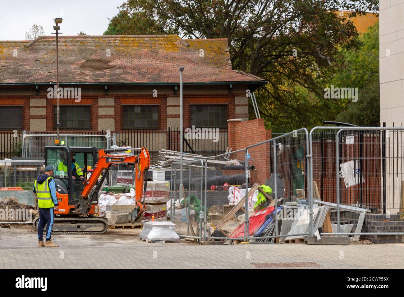 Costruttori o operai di costruzione usando un digger su una costruzione sito Foto Stock