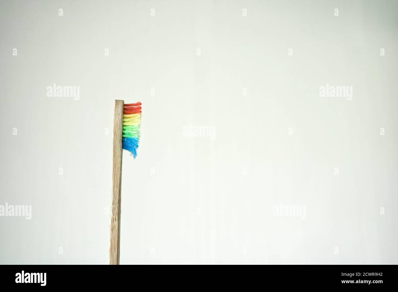 Profilo di uno spazzolino di bambù singolo usato con setole arcobaleno Foto Stock