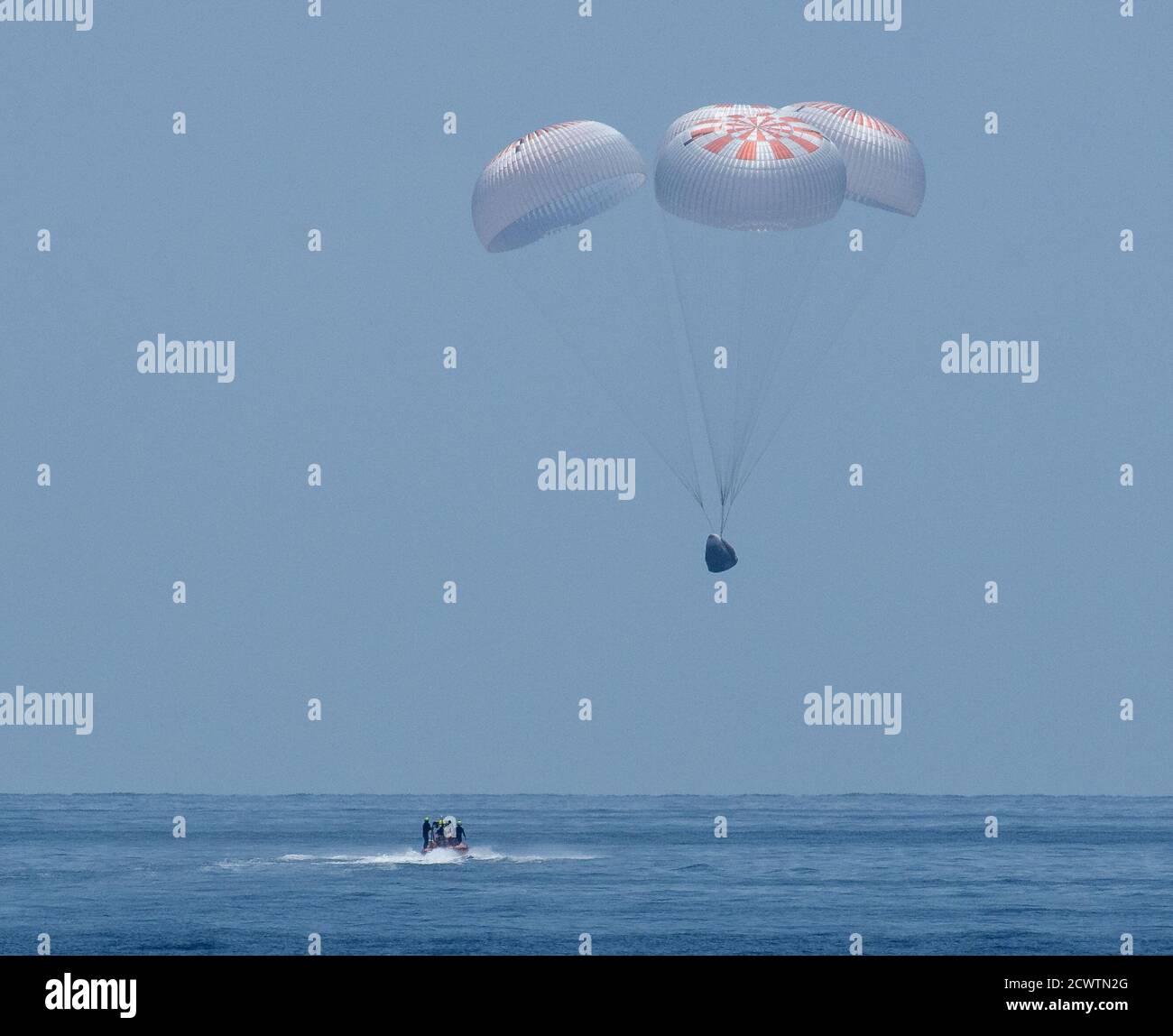 SpaceX Demo-2 Landing la SpaceX Crew Dragon Endeavour è visto come atterra con astronauti della NASA Robert Behnken e Douglas Hurley a bordo nel Golfo del Messico al largo della costa di Pensacola, Florida, Domenica, 2 agosto 2020. Il volo di prova Demo-2 per il programma Commercial Crew della NASA è stato il primo a consegnare gli astronauti alla Stazione spaziale Internazionale e a restituirli in modo sicuro alla Terra a bordo di una navicella spaziale costruita e gestita in commercio. Behnken e Hurley tornarono dopo aver trascorso 64 giorni nello spazio. Foto Stock