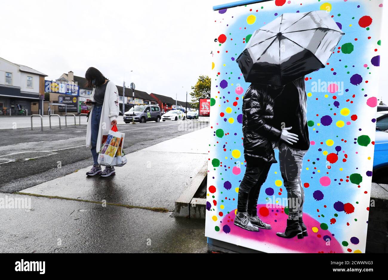 Un nuovo murale intitolato "abbraccio la pioggia" dell'artista urbano "Johnman Spraycan" è visto su una scatola elettrica a Dublino. Foto Stock