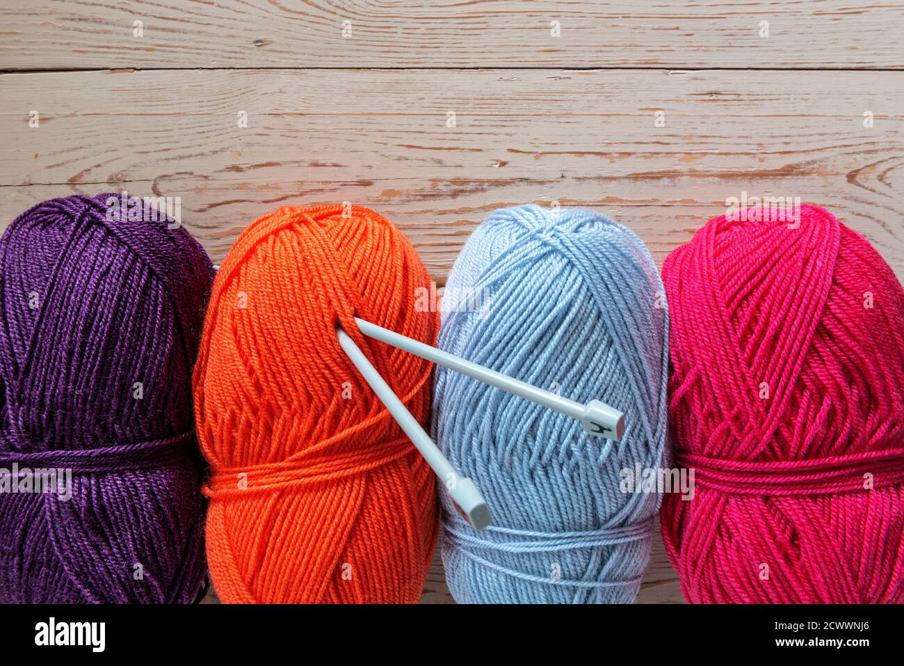Quattro palle di lana di maglia dai colori vivaci. Foto Stock