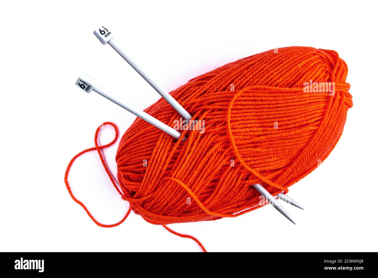 Palla di lana d'arancia con aghi in maglia su bianco. Foto Stock