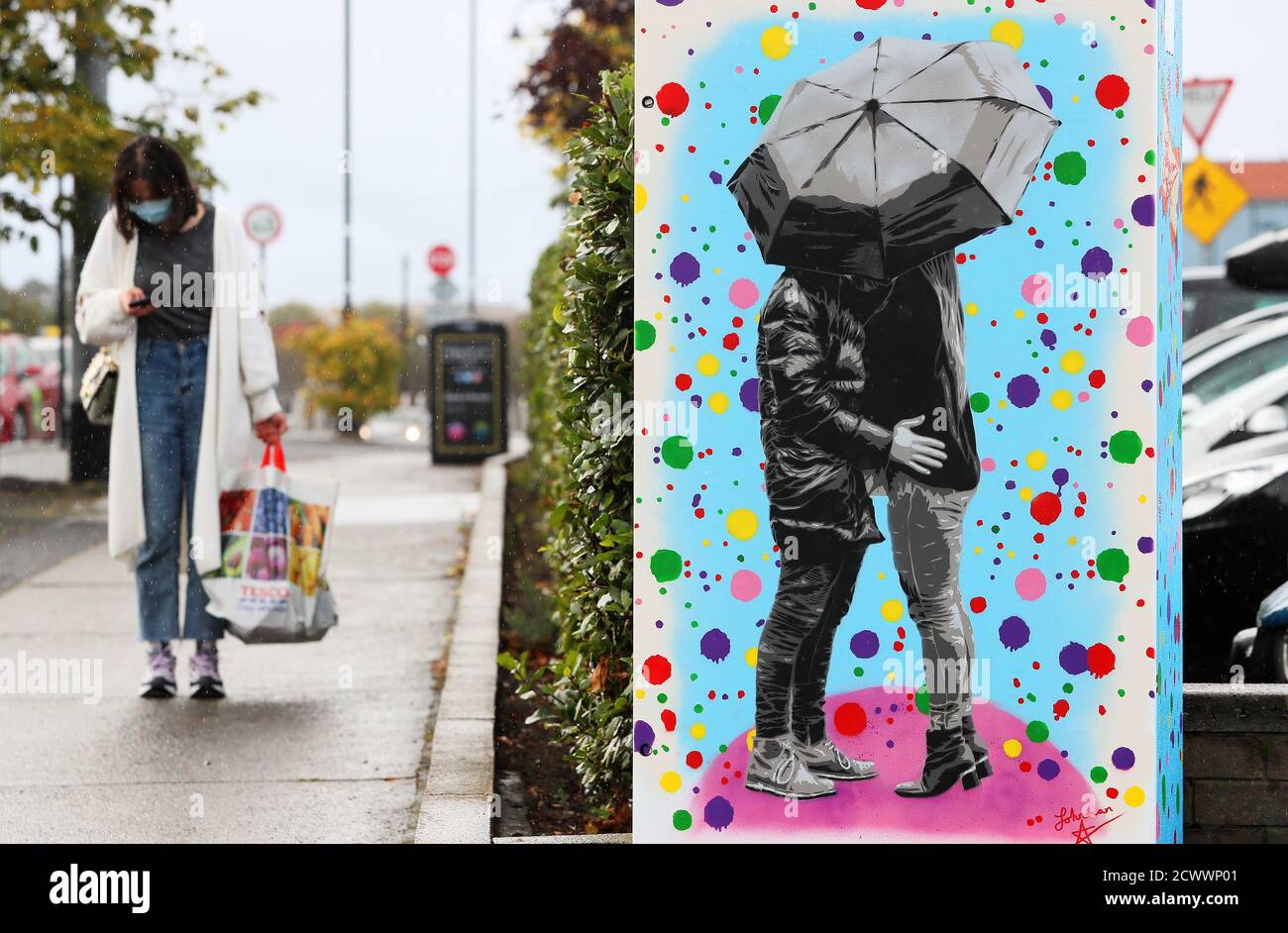 Un nuovo murale intitolato "abbraccio la pioggia" dell'artista urbano "Johnman Spraycan" è visto su una scatola elettrica a Dublino. Foto Stock