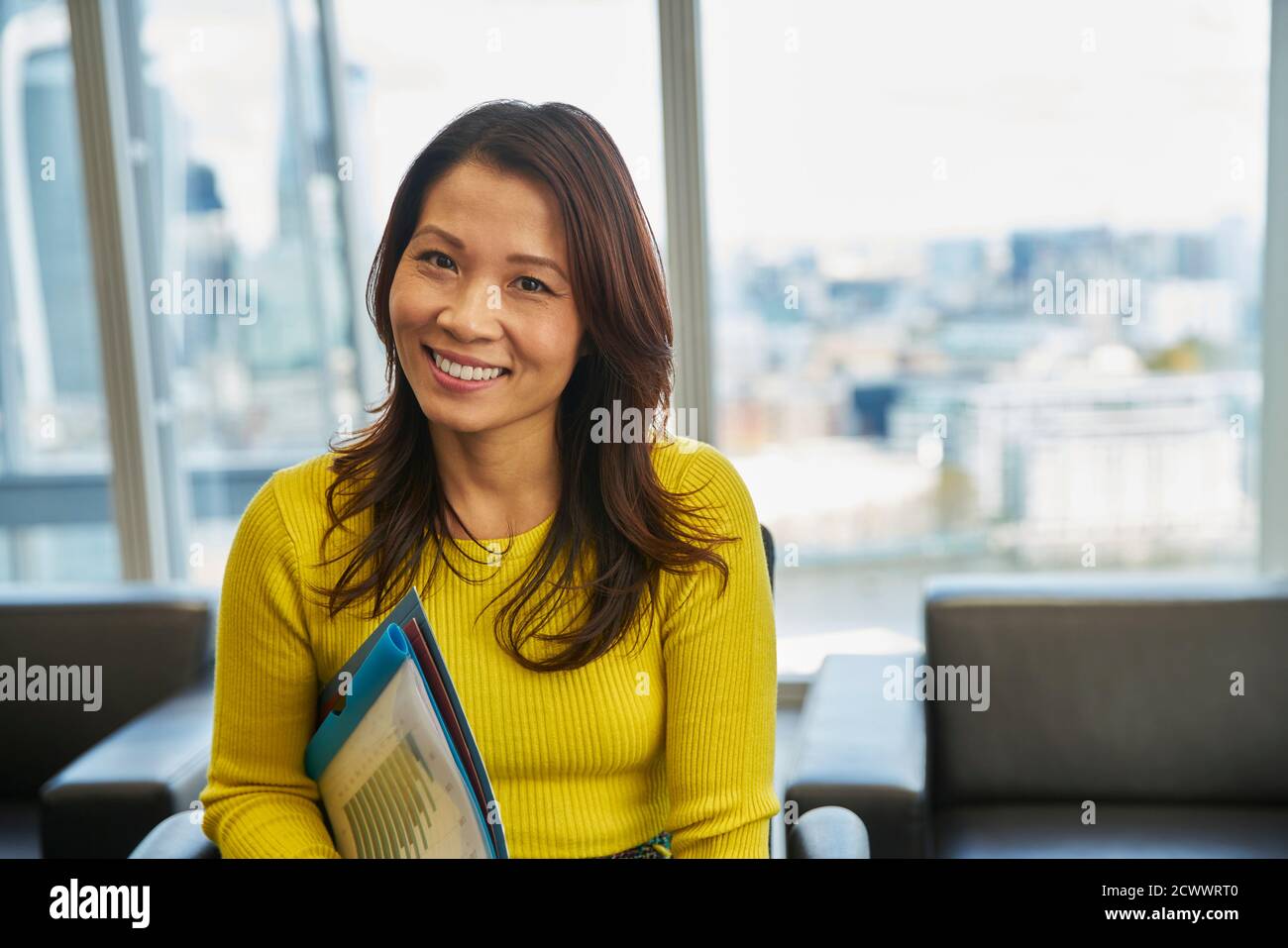 Ritratto sorridente imprenditrice con i documenti di office Foto Stock