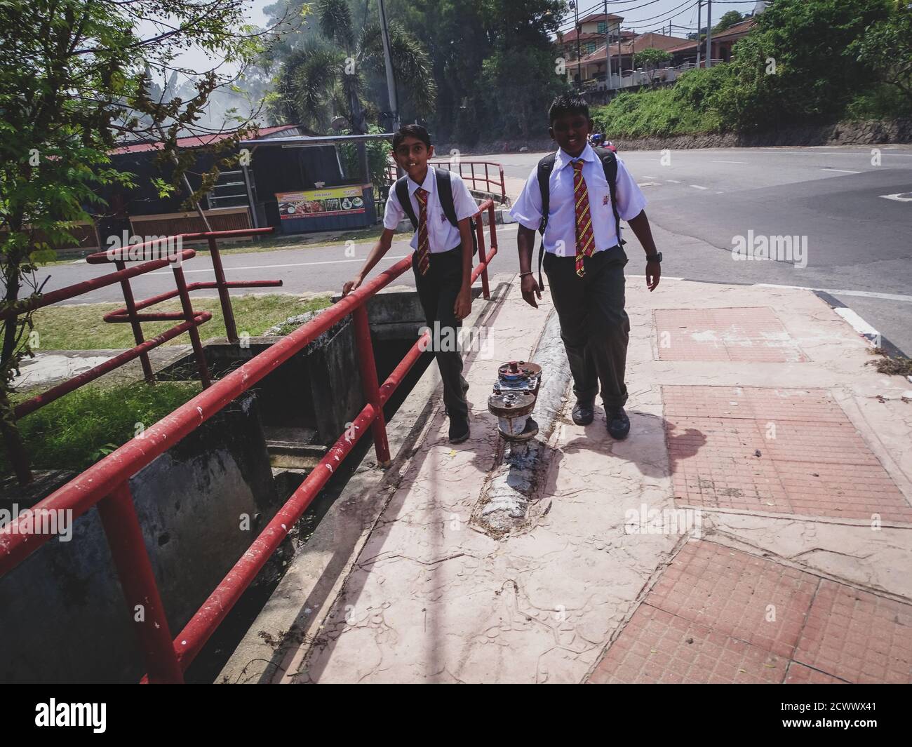 Due ragazzi asiatici stanno camminando a casa dopo la scuola Foto Stock