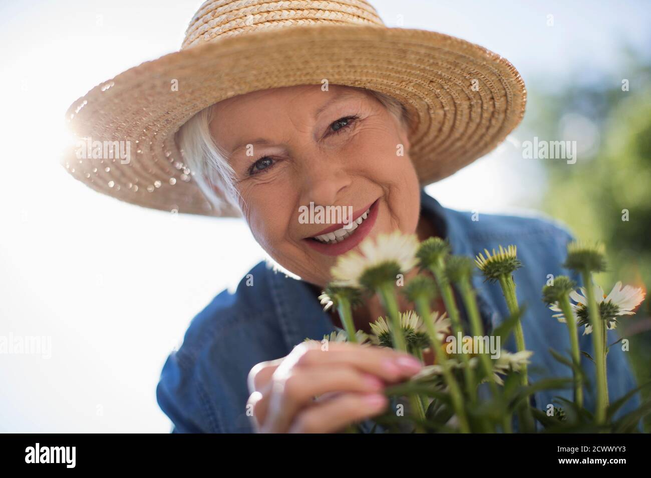 Primo piano ritratto felice donna anziana giardinaggio in cappello di paglia Foto Stock