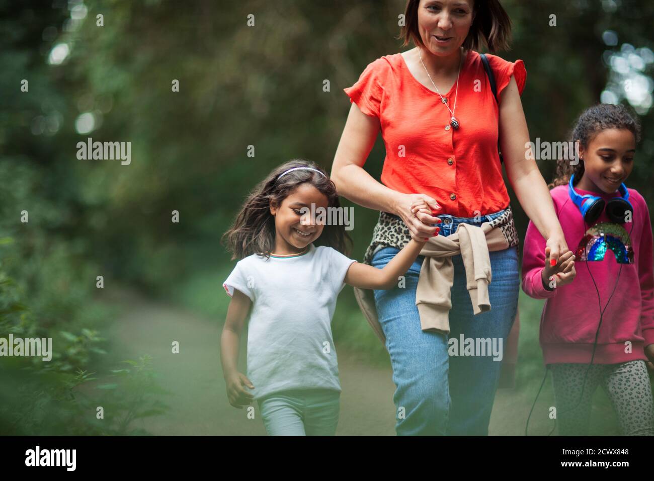 Madre e figlie escursioni sul sentiero nei boschi Foto Stock