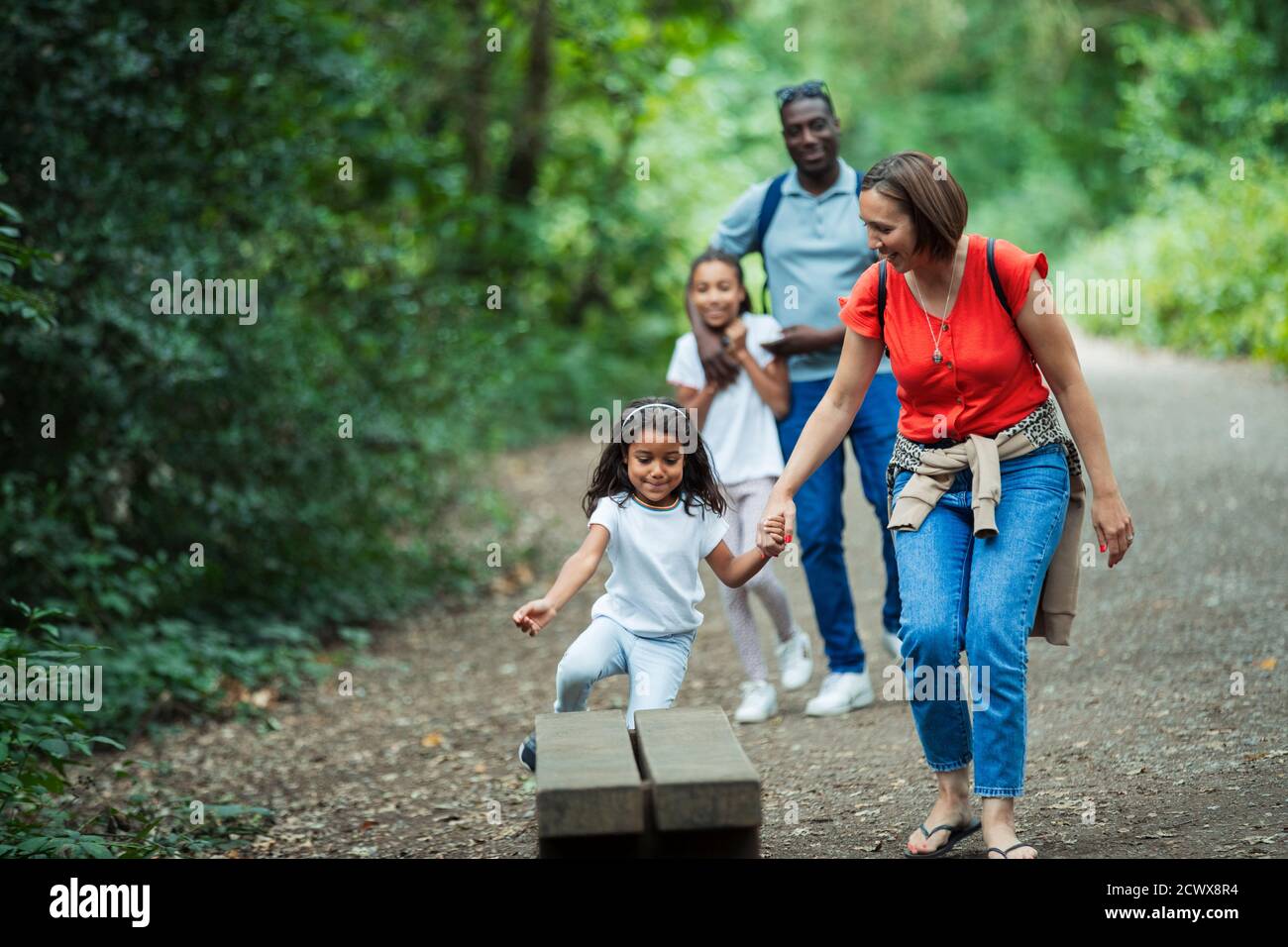 Felice famiglia a piedi su sentiero in boschi Foto Stock