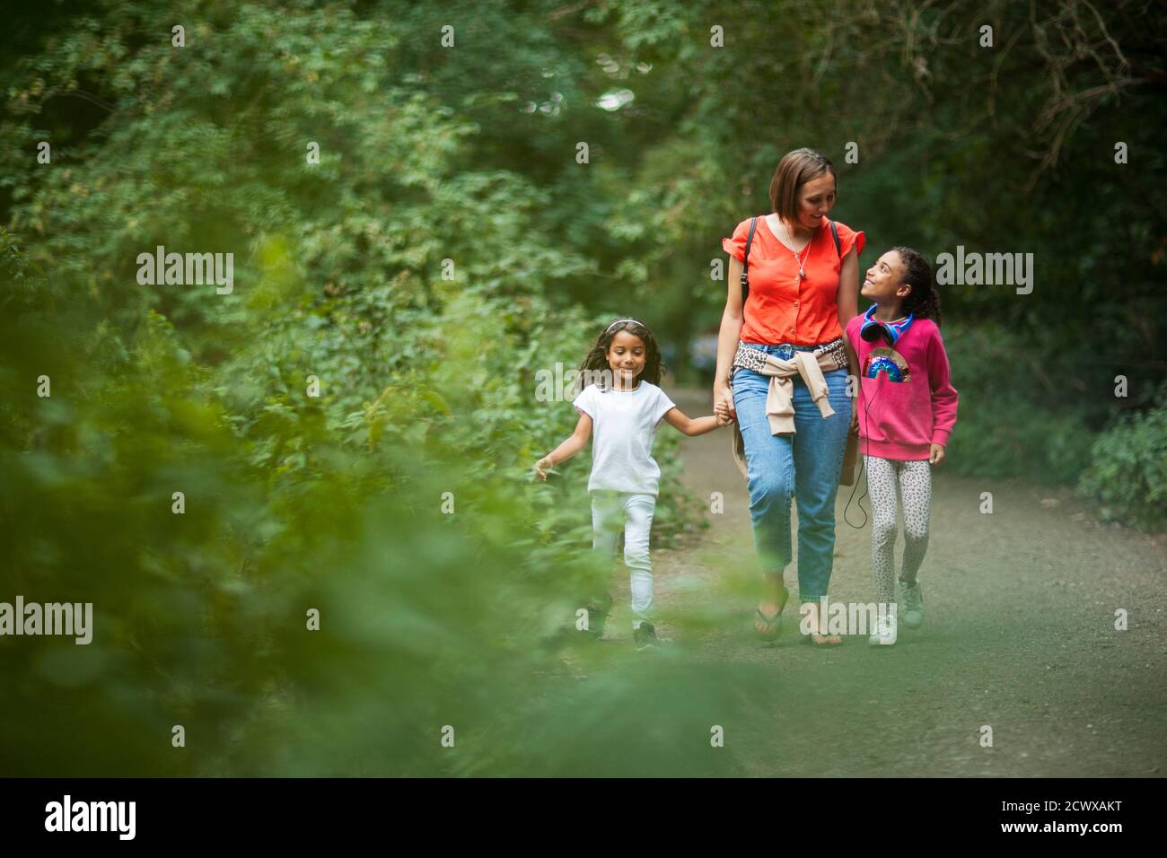 Madre e figlie che camminano sul sentiero nei boschi Foto Stock