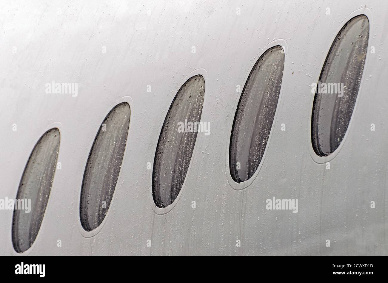 Oblò di un aereo tempo umido in gocce di pioggia d'acqua, primo piano Foto Stock