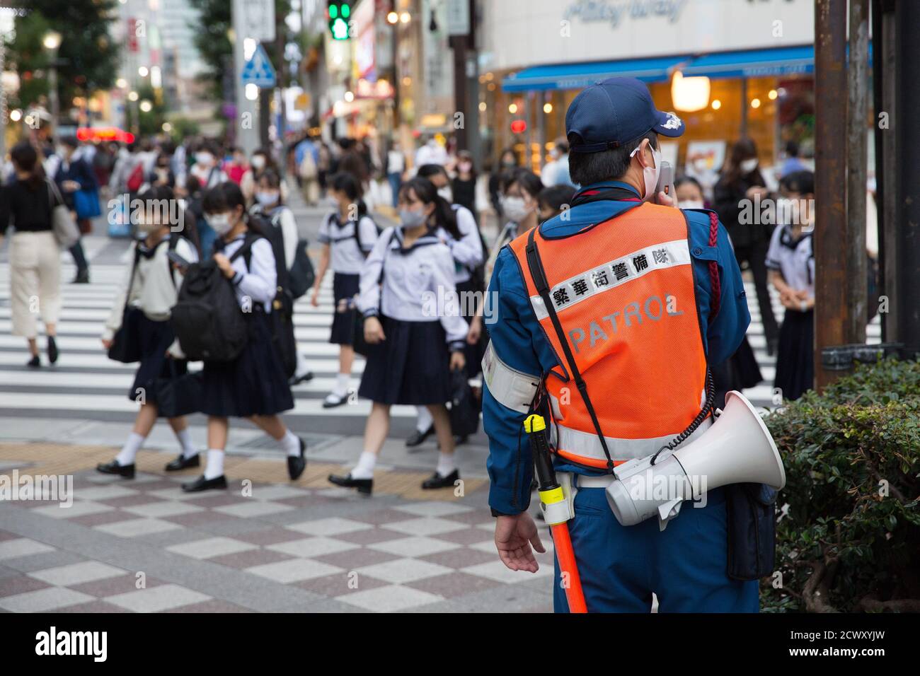 Il funzionario locale consiglia ai pedoni di lavarsi le mani regolarmente su un megafono e di mantenere la distanza sociale a Ikebukuro, Tokyo.Koronon, una mascotte giapponese anti-coronavirus che mette a disposizione maschere usa e getta e fa conoscere le onde del coronavirus (Covid-19) ai pedoni di Ikebukuro, Tokyo. Koronon può anche essere prenotato per visitare scuole e aziende per condividere il suo messaggio sull'igiene e altre misure per combattere Covid-19. Foto Stock