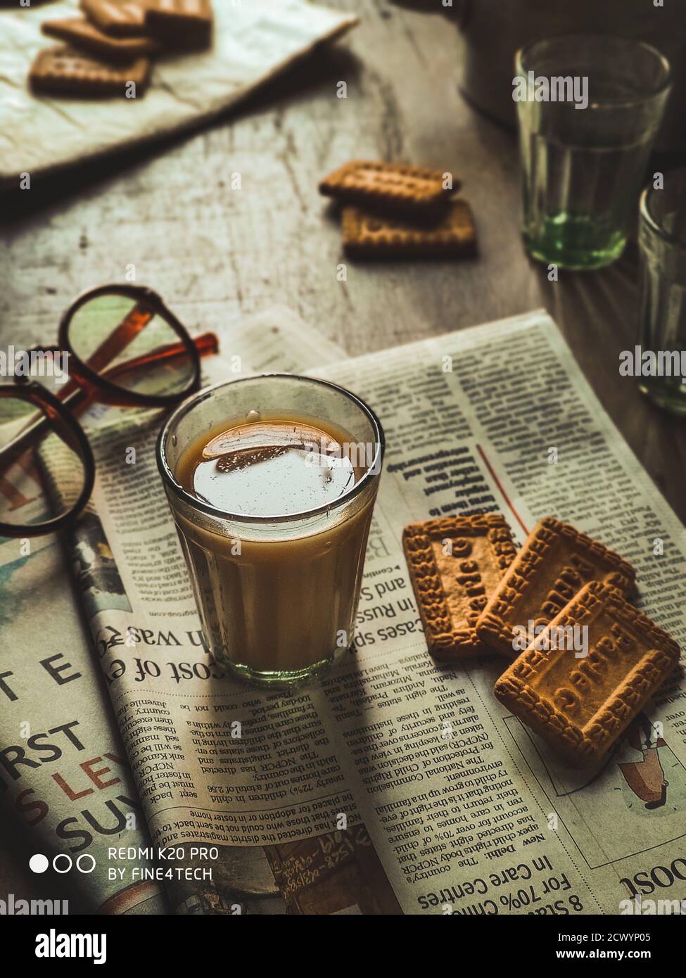 Chai indiano in tazze di vetro con bollitore di metallo e altre masala per preparare il tè. Foto Stock