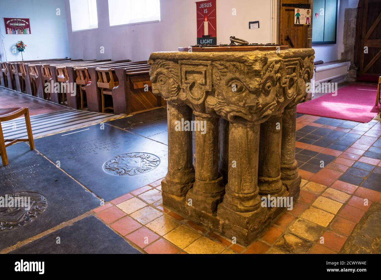 Il carattere tardo Norman nella chiesa di St Mary, Wootton sud nel Norfolk nord-occidentale. Ha teste intagliate su ogni angolo e si erge su nove gambe. Foto Stock