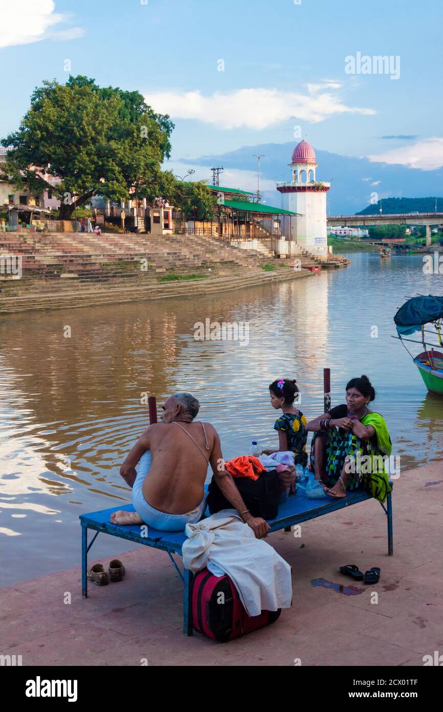 Chitrakoot, Madhya Pradesh, India : UNA famiglia di pellegrini riposa presso il fiume Mandakini a Ramghat dove durante il loro periodo di esilio Lord Rama, Lakshmana Foto Stock